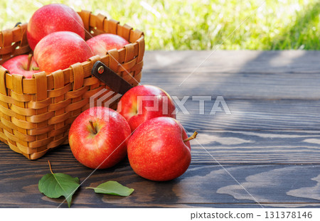 Basket of ripe red apples on a wooden table 131378146