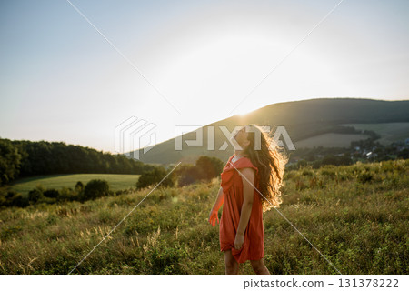 Etheric girl in red dress standing on meadow. 131378222