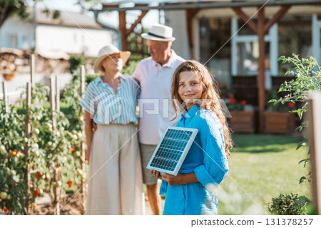 Family promoting renewable energy with solar technology at home. 131378257