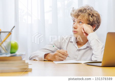 Schoolboy studying at home, doing homework 131378389