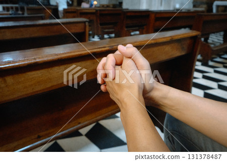 side view of a man with interlaced fingers in prayer side view of a man with interlaced fingers in prayer 131378487