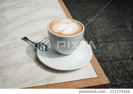 closeup of macchiato with heart foam on cafe table 131378488