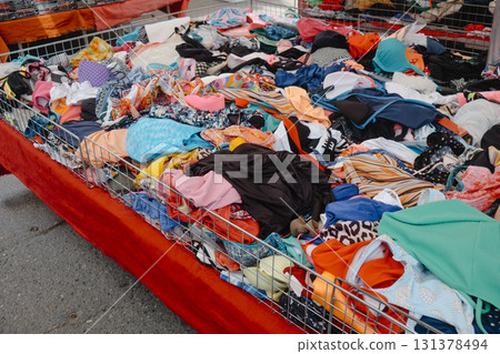 colorful clothes and textiles spread in bins at a stall colorful clothes and textiles spread in bins at a stall 131378494