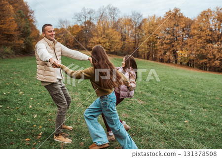 Father dancing with daughters, holding hands. Father dancing with daughters, holding hands. 131378508