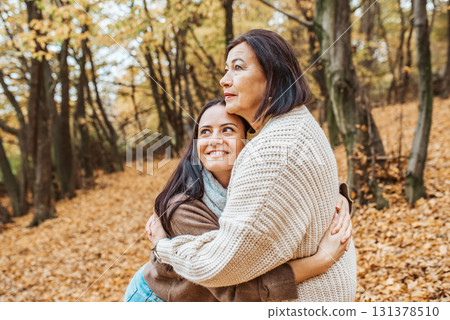 Mature daughter with older mom in the middle of fores, hugging. Mother's day concept. Mature daughter with older mom in the middle of fores, hugging. Mother's day concept. 131378510