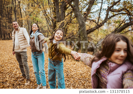 Multigenerational family portrait. Parents, grandma and daughters on walk in forest. Multigenerational family portrait. Parents, grandma and daughters on walk in forest. 131378515