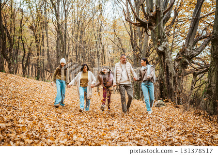 Multigenerational family portrait. Parents, grandma and daughters on walk in forest. Multigenerational family portrait. Parents, grandma and daughters on walk in forest. 131378517