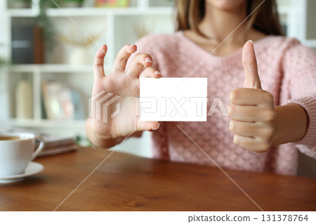 Woman hands showing business card gesturing thumb up 131378764
