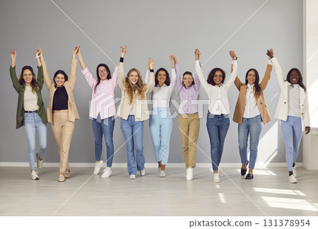 Group of happy business women looking at camera, holding hands up and having fun. 131378954