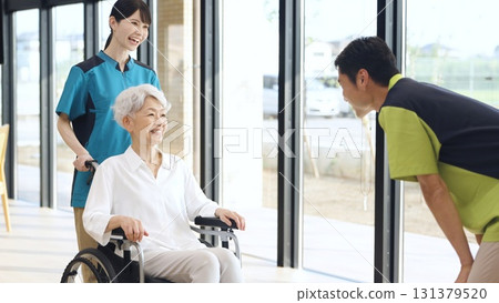 Elderly people and caregivers greeting each other at a nursing home Elderly people and caregivers greeting each other at a nursing home 131379520