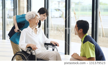Elderly people and caregivers greeting each other at a nursing home Elderly people and caregivers greeting each other at a nursing home 131379523