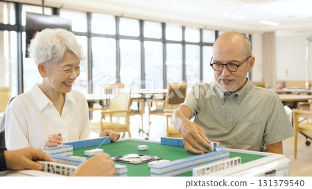 Asian elderly people playing mahjong in a care home 131379540