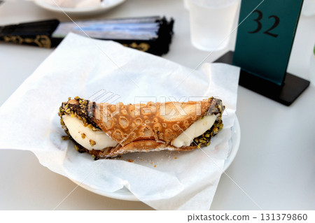 Cannoli on white plate in italian cafe 131379860