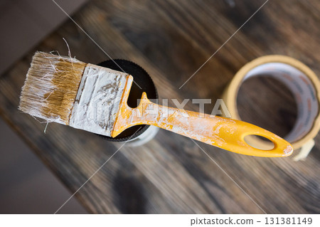 Engage in DIY chair restoration using a paint brush and protective gloves for the process Engage in DIY chair restoration using a paint brush and protective gloves for the process 131381149