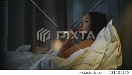 Before Sleeping, Girl in Bed Snacks in Front of TV 131381150