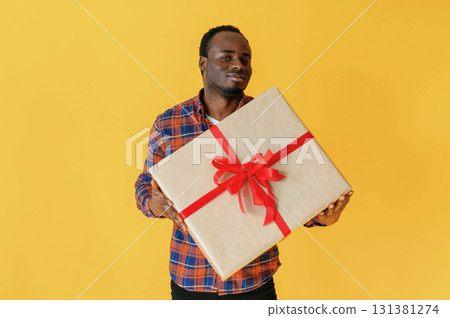 Cafe worker. Black man is in the studio against yellow background Cafe worker. Black man is in the studio against yellow background 131381274