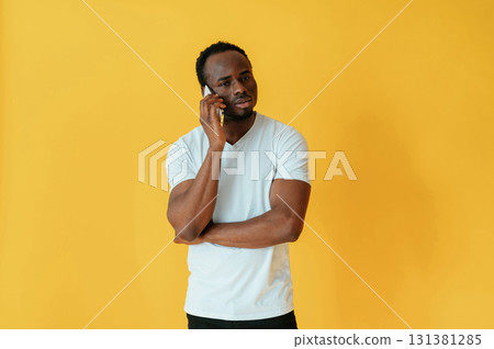 Cafe worker. Black man is in the studio against yellow background 131381285