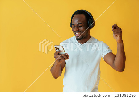 Cafe worker. Black man is in the studio against yellow background Cafe worker. Black man is in the studio against yellow background 131381286