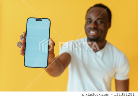 Cafe worker. Black man is in the studio against yellow background 131381291
