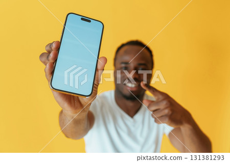 Cafe worker. Black man is in the studio against yellow background Cafe worker. Black man is in the studio against yellow background 131381293