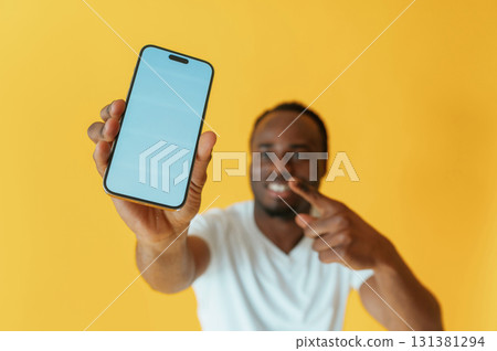 Cafe worker. Black man is in the studio against yellow background 131381294