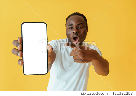 Cafe worker. Black man is in the studio against yellow background Cafe worker. Black man is in the studio against yellow background 131381298