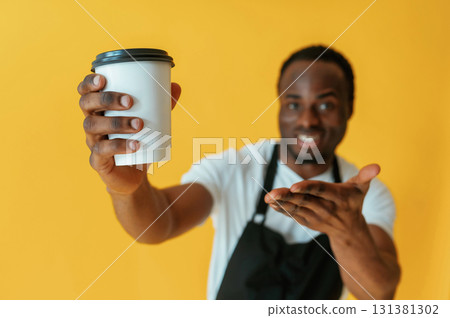 Cafe worker. Black man is in the studio against yellow background 131381302