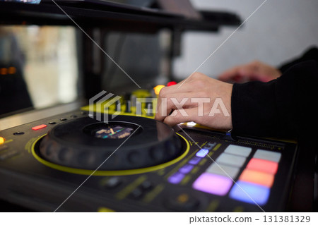 Witness the DJ mixing equipment performing live and in action at a vibrant music event Witness the DJ mixing equipment performing live and in action at a vibrant music event 131381329