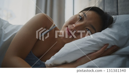 Woman Lying on Pillow, Smiling Softly After Waking Up 131381340