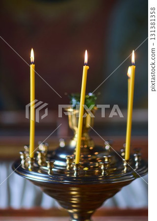 An Elegant Candle Holder featuring Lit Candles within a Beautiful and Serene Setting 131381358