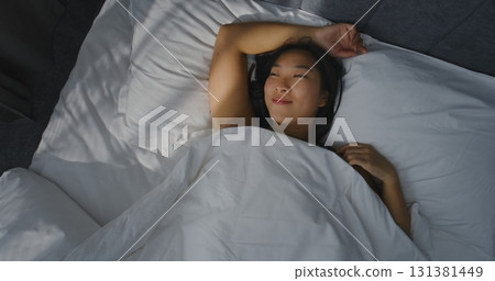 Young Girl Falls into Bed With Arms Outstretched, Smiling, Enjoying Moment 131381449