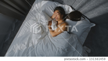 Beautiful Young Woman Wakes Up in Bedroom, Squinting From Bright Sunlight 131381459