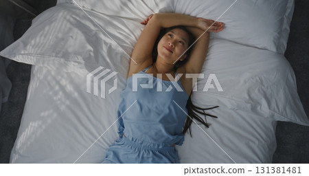 Young Girl Falls into Bed With Arms Outstretched, Smiling, Enjoying Moment Young Girl Falls into Bed With Arms Outstretched, Smiling, Enjoying Moment 131381481