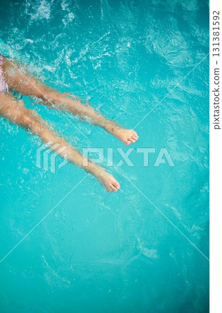 Teen girl enjoying a relaxing swim on a sunny summer day in a vibrant pool Teen girl enjoying a relaxing swim on a sunny summer day in a vibrant pool 131381592