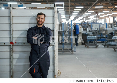 Just standing and smiling. Factory worker is indoors Just standing and smiling. Factory worker is indoors 131381680