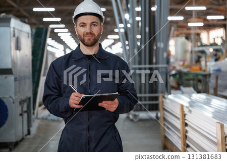 Factory worker is indoors with hard hat Factory worker is indoors with hard hat 131381683