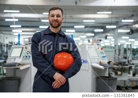 Break time, standing. Factory worker is indoors with hard hat Break time, standing. Factory worker is indoors with hard hat 131381845