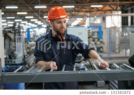 Industrial line, working. Factory worker is indoors with hard hat Industrial line, working. Factory worker is indoors with hard hat 131381872