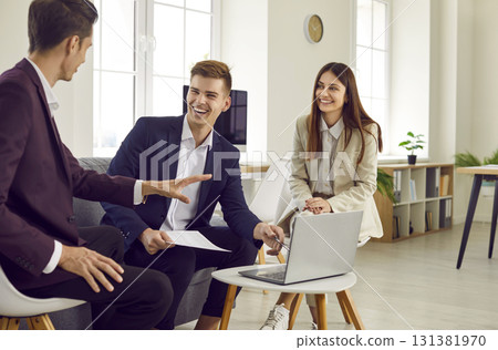 Three young business people at work in office talking and having discussion. Three young business people at work in office talking and having discussion. 131381970