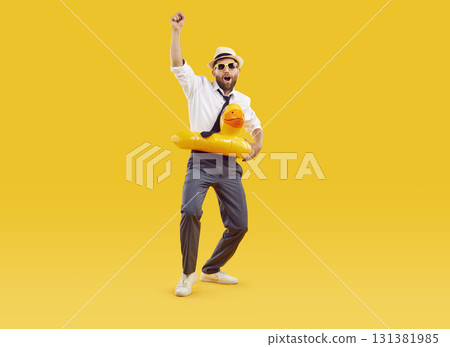 Happy young businessman with funny swim ring enjoying parties on summer vacation 131381985