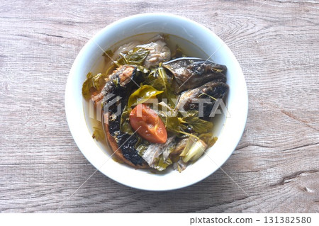 boiled smoked dry snake head fish with tamarind leaf in spicy and sour soup on bowl boiled smoked dry snake head fish with tamarind leaf in spicy and sour soup on bowl 131382580