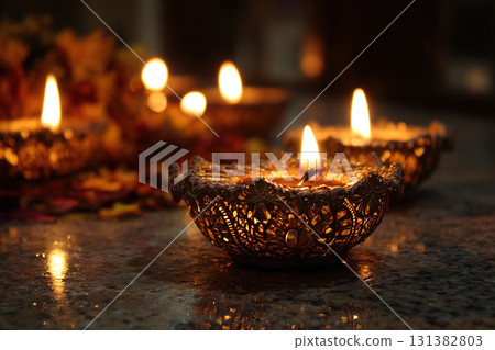 Beautiful diya lamps glow with a festive glow in honor of the main holiday of Diwali. Lit diyas decorate the home on the festive evening. 131382803