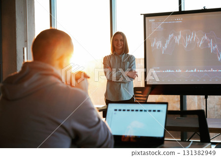 Beautiful sun beam. Female business trainer is against projector with business data, teaching the man 131382949