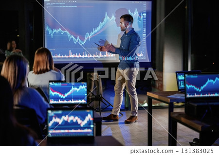 Graph is going up. Male business trainer is against projector with data, teaching people 131383025