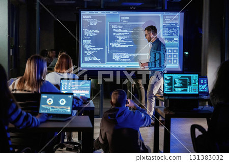 Talking about project. Male business trainer is against projector with data, teaching people 131383032