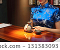 A woman in a Chinese dress is enjoying hot sake at an izakaya 131383093