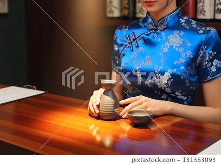 A woman in a Chinese dress is enjoying hot sake at an izakaya 131383093