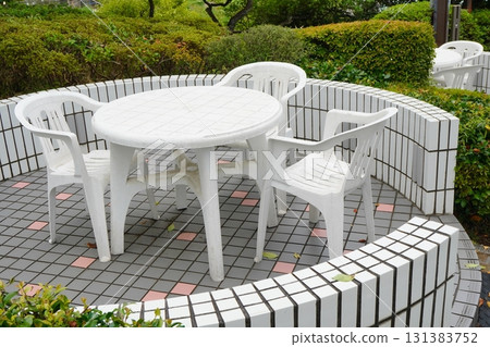 Photo of a white plastic garden table and chairs set up outdoors Photo of a white plastic garden table and chairs set up outdoors 131383752