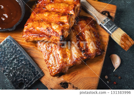 Spicy hot grilled spare ribs from a summer BBQ served with a hot chili pepper and fresh tomatoes Spicy hot grilled spare ribs from a summer BBQ served with a hot chili pepper and fresh tomatoes 131383996