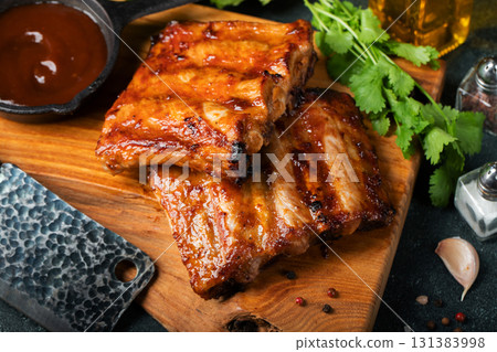 Spicy hot grilled spare ribs from a summer BBQ served with a hot chili pepper and fresh tomatoes 131383998